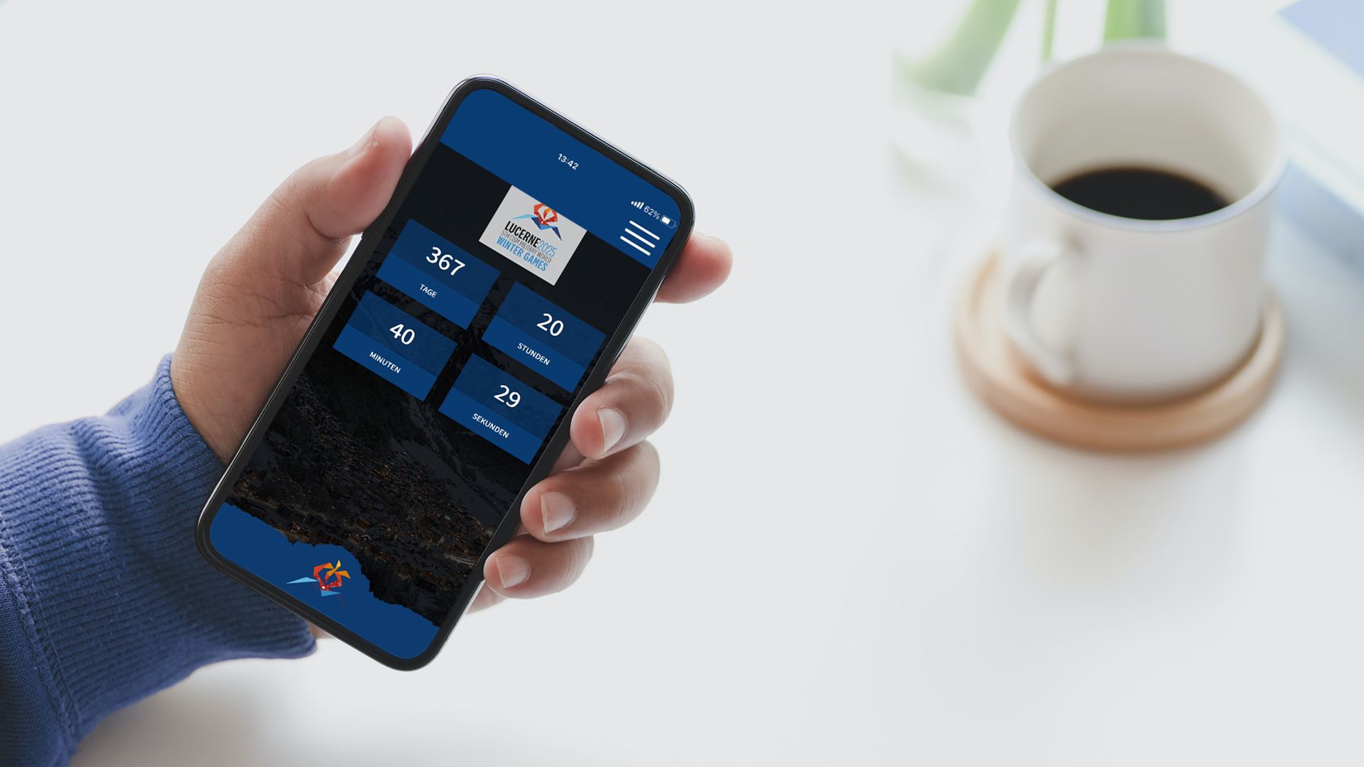 Hand hält Smartphone auf dem die Event-Webseite der Military World Winter Games 2025 angezeigt wird.