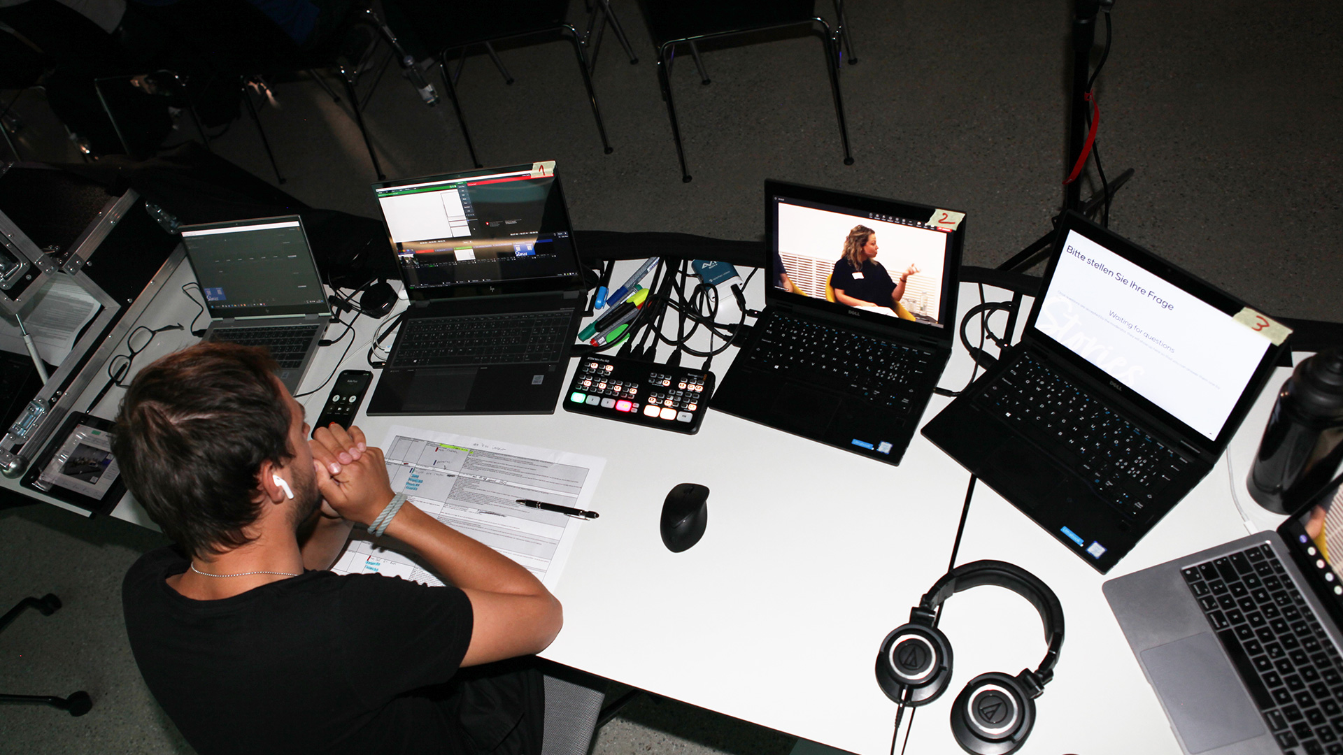 Streaming Studio Mitarbeiter vor mehreren Bildschirmen.