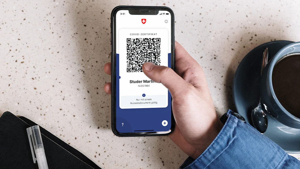 Smartphone mit geöffneter «COVID Certificate»-App und Covid-Zertifikat mir QR-Code.