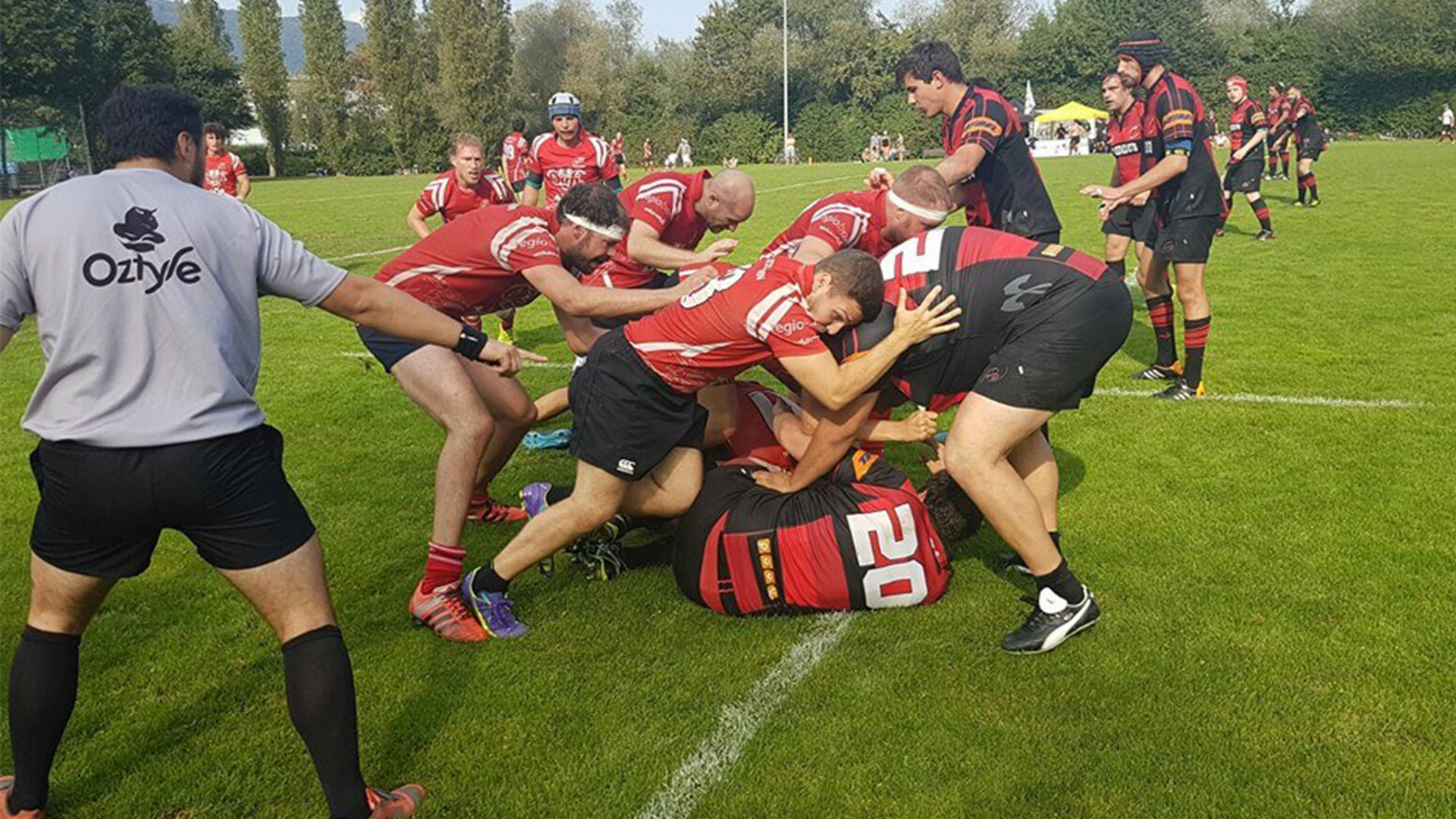 Un joueur de rugby de l’équipe adverse est à terre et l’équipe tente de récupérer le ballon.