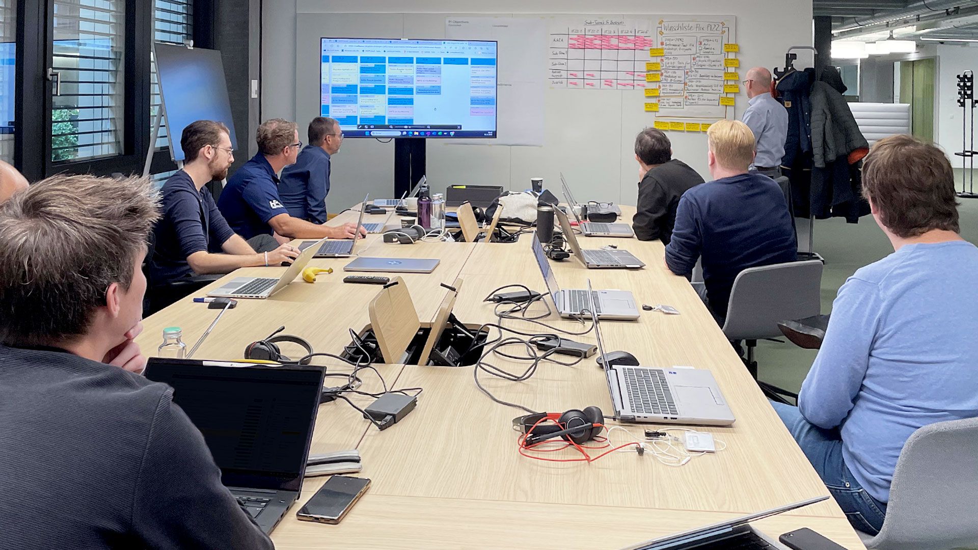Planification PI avec neuf personnes regardant un tableau Kanban.