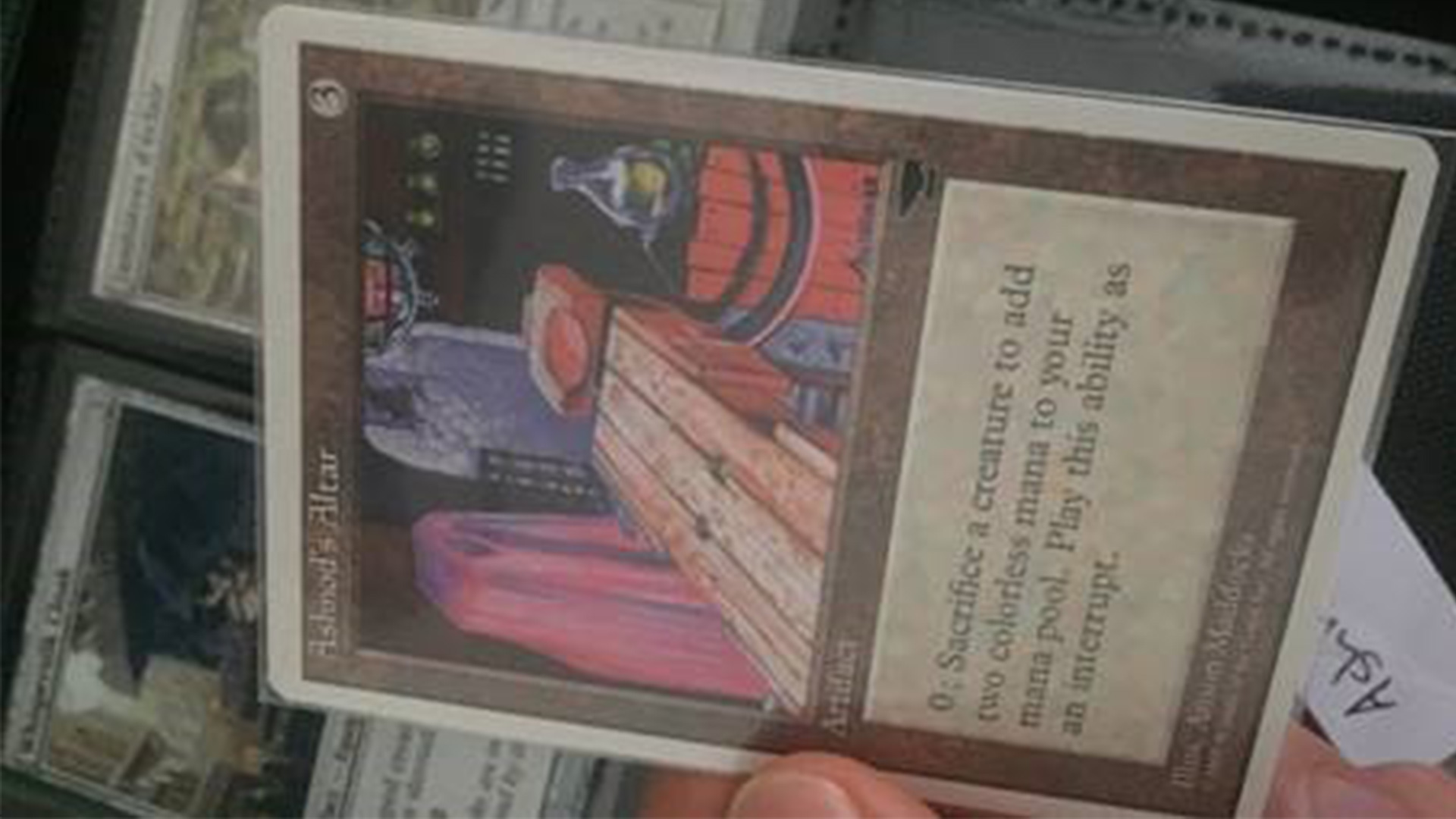 Une main tient une carte plus ancienne, dessinée à la main.