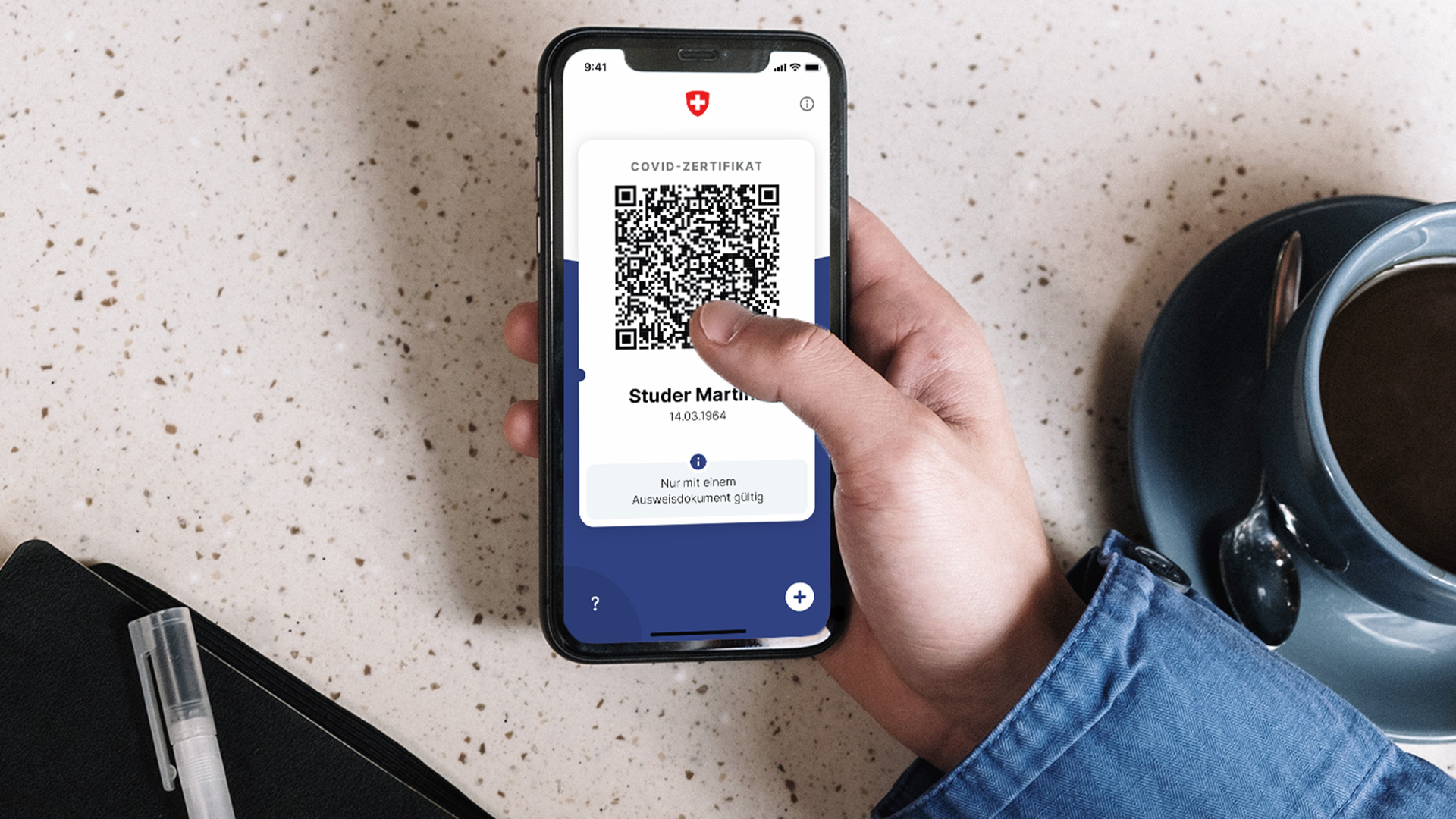 Smartphone avec l’application « Certificats COVID » ouverte, affichant un certificat COVID avec un code QR.